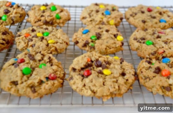 Freshly baked monster cookies cooling on wire rack
