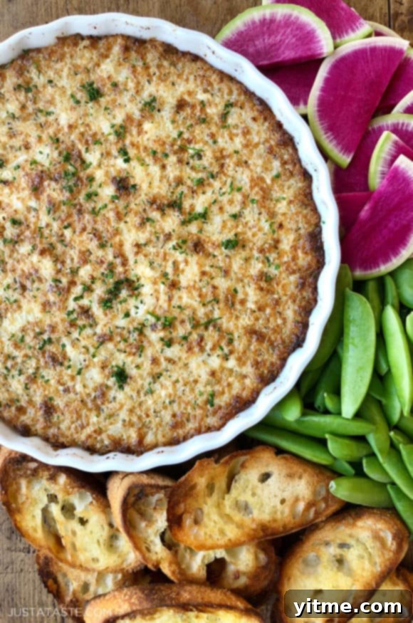 A white dish of Crack Dip surrounded by veggies and bread