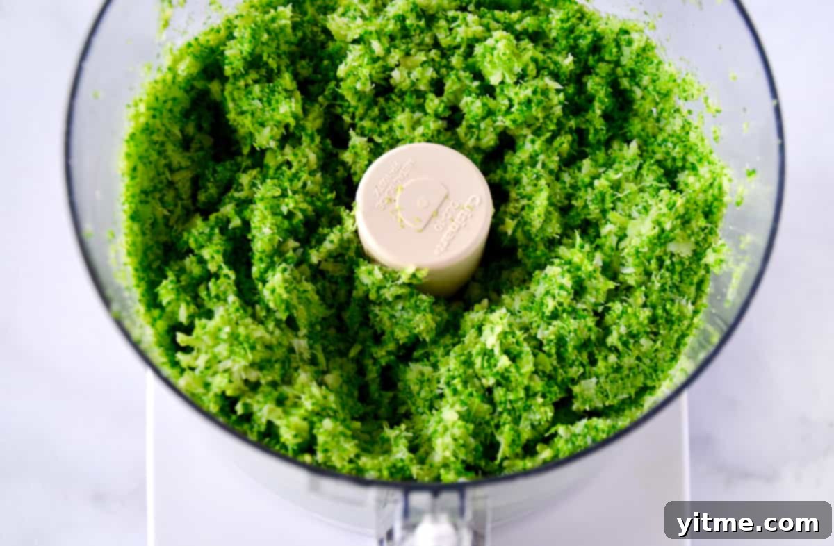 Crispy Baked Broccoli Bites 3 Finely ground blanched broccoli in the bowl of a food processor, ready to be mixed with other ingredients.