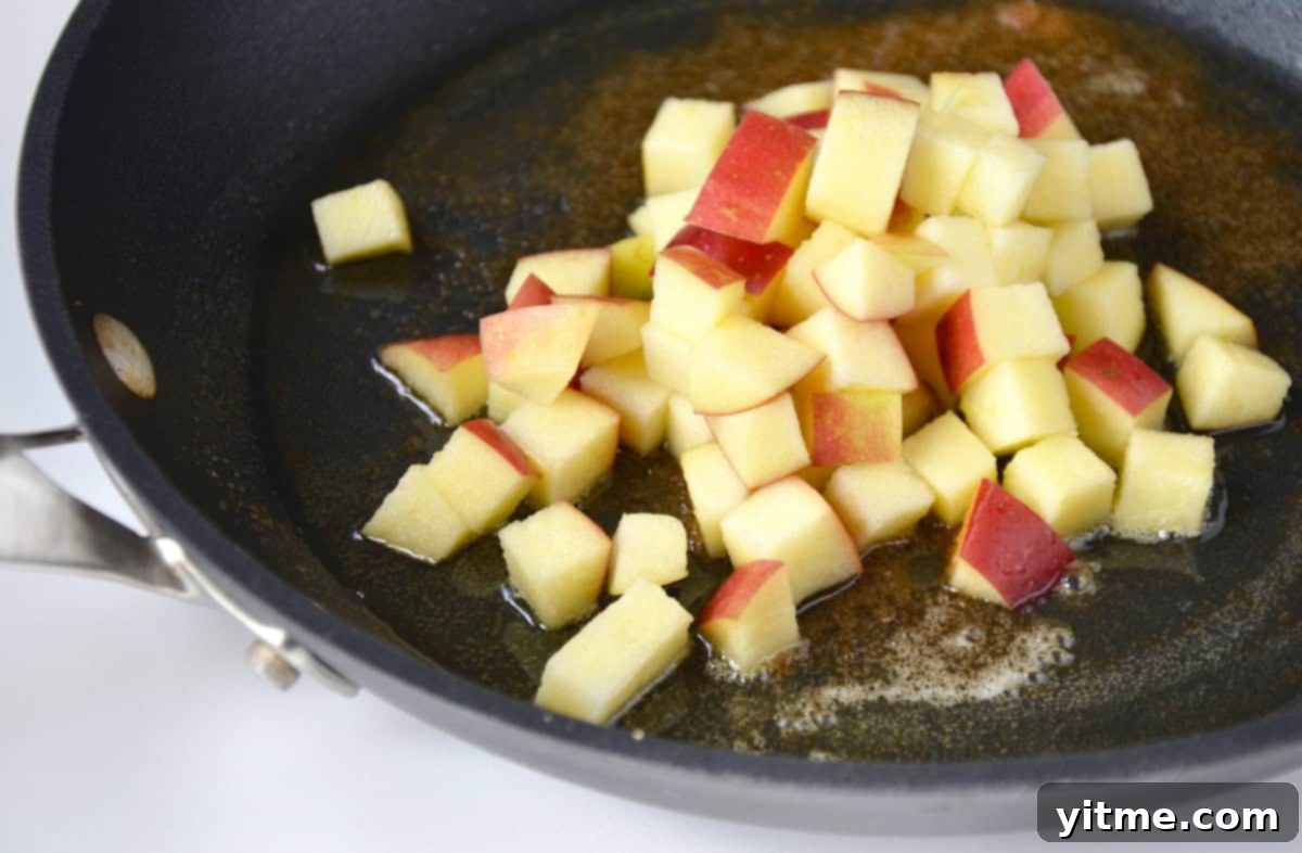 Chopped, sautéed apples with brown sugar in a pan.