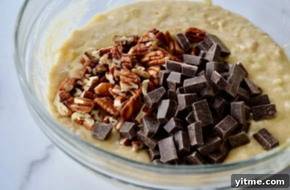 Greek Yogurt Banana Bread Bliss 5 A glass bowl with banana bread batter, chopped nuts and chocolate chunks