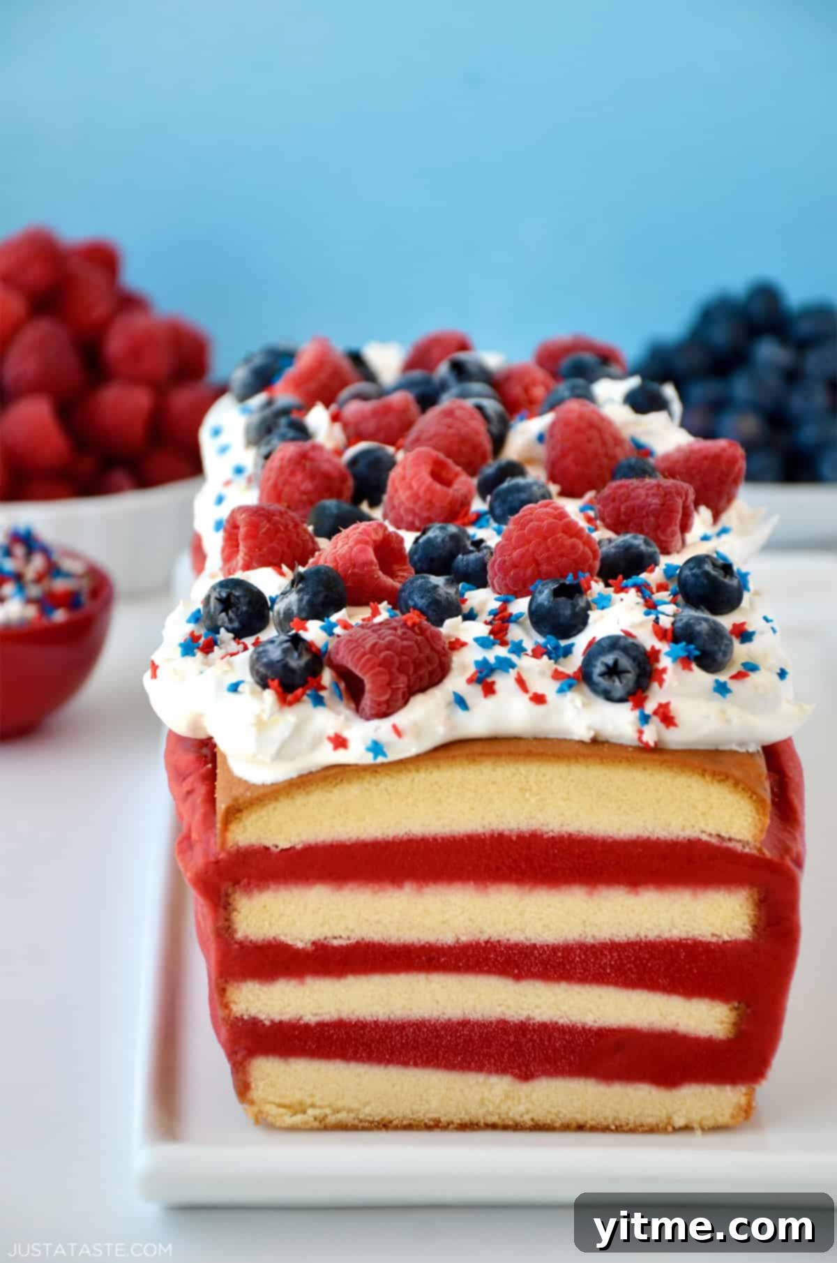A layered ice cream cake with pound cake, raspberry sorbet, whipped cream, and patriotic sprinkles.