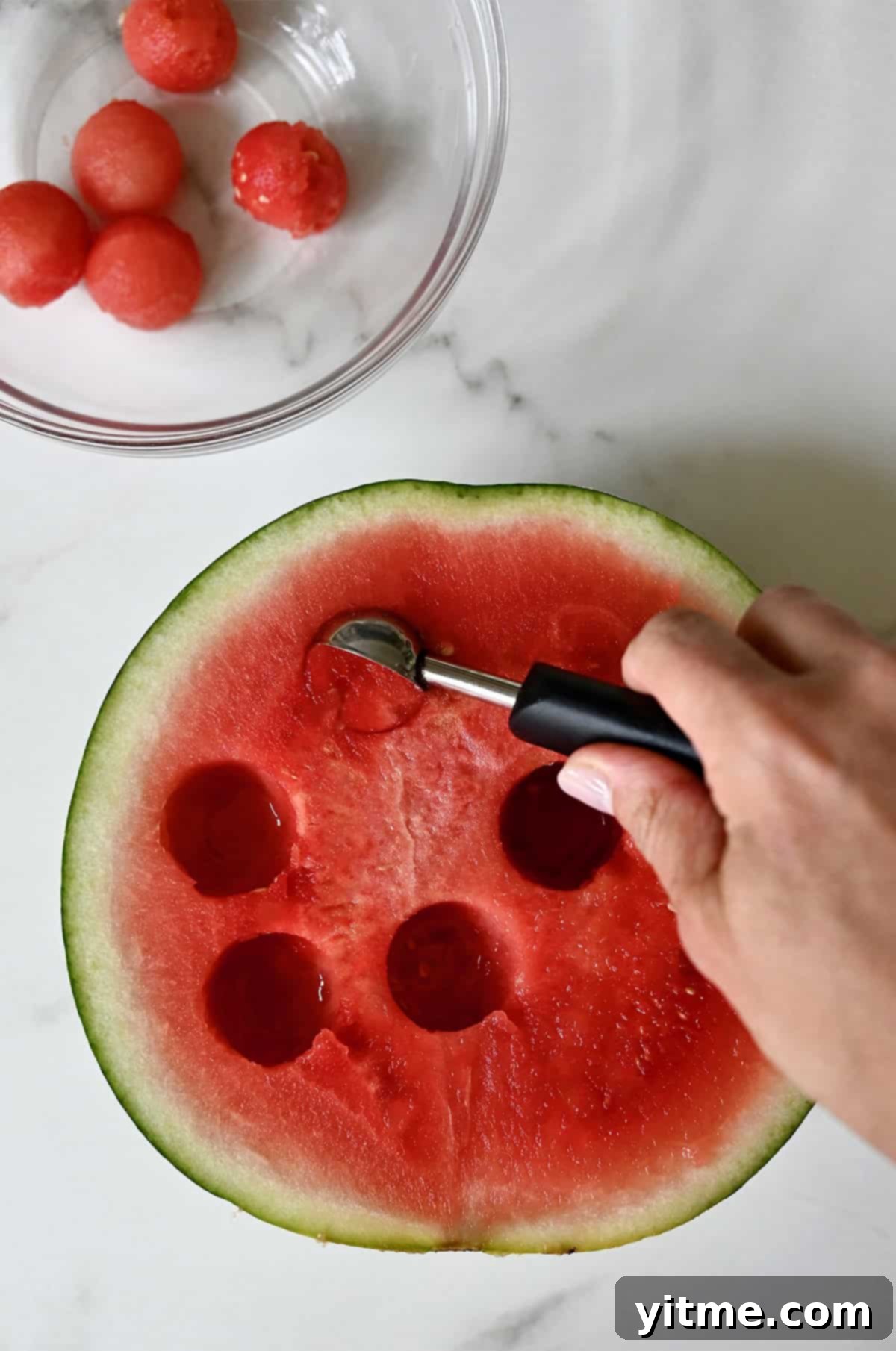 Using a melon baller to get perfect round balls of watermelon