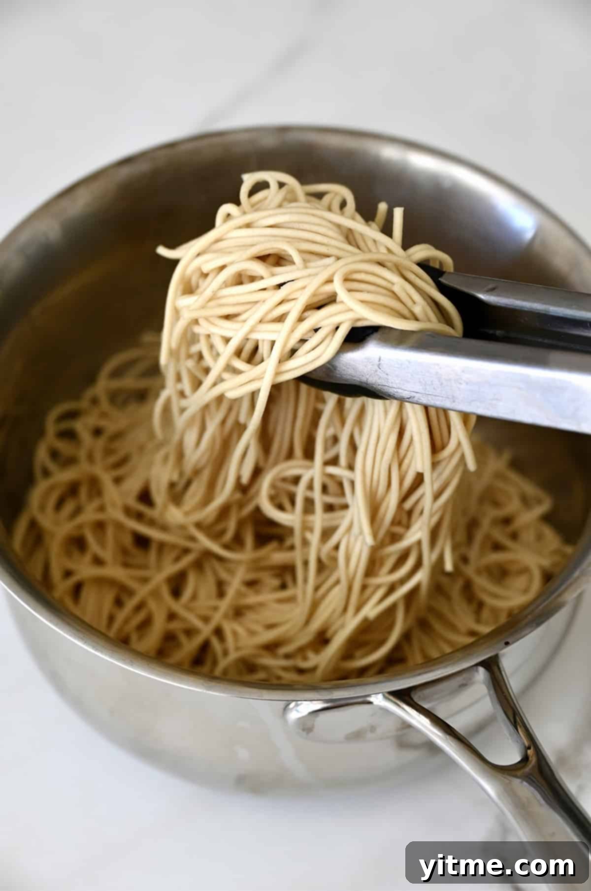 Cooked lo mein noodles in a pan.