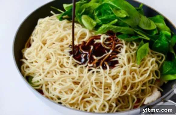 Adding sauce to noodles.