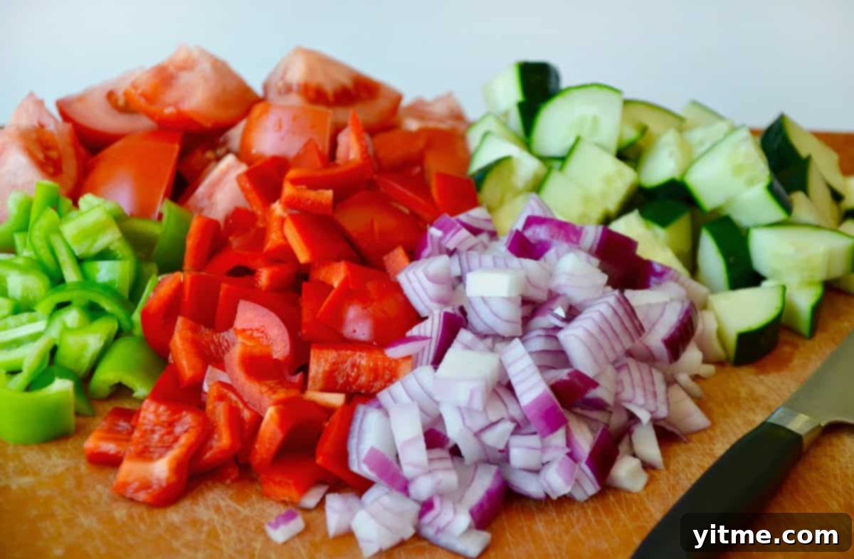 Chopped ingredients for gazpacho: tomato, red onion, peppers, cucumber.