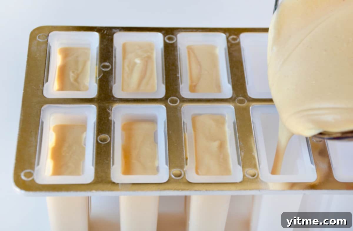 Creamy Peanut Butter Fro-Yo Pops 5 A popsicle mold being filled with a peanut butter-yogurt mixture.