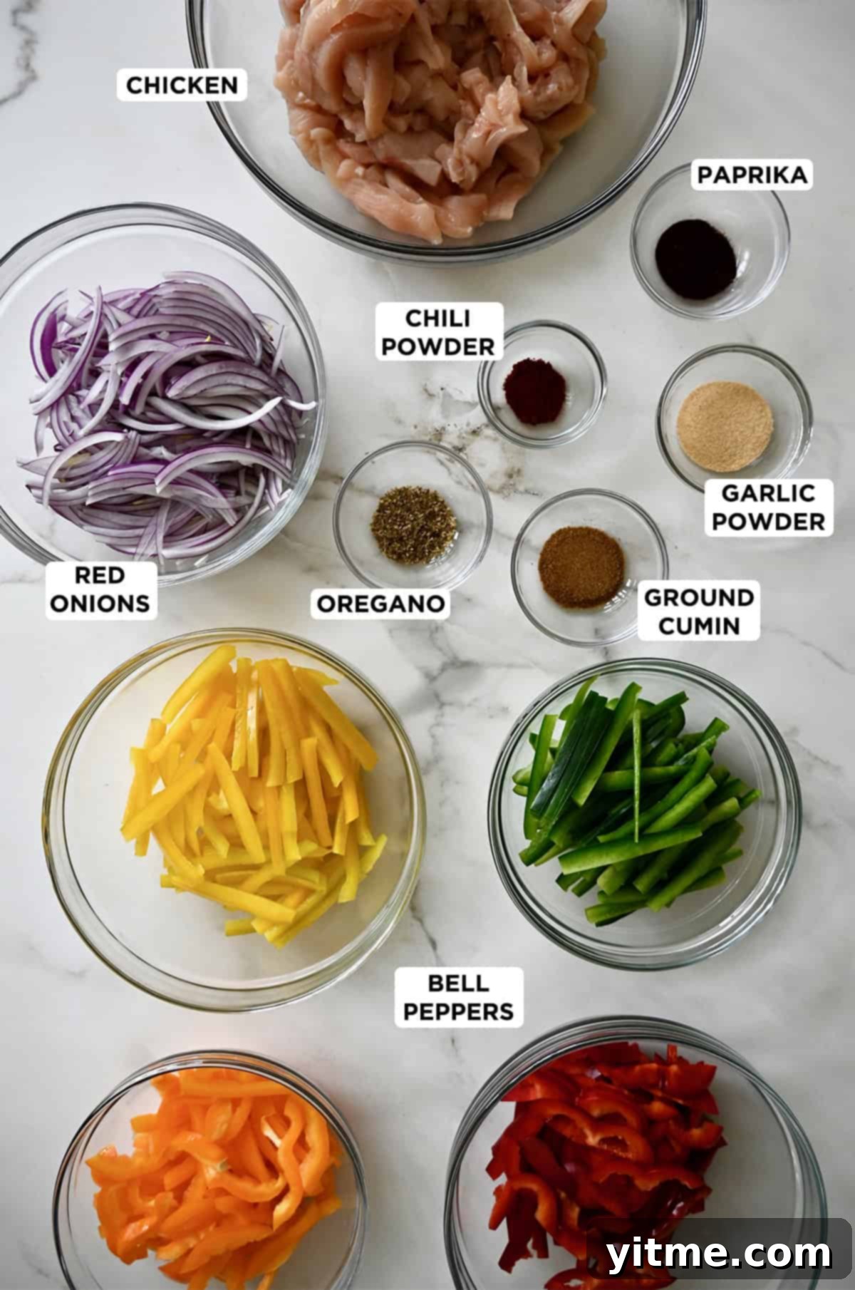 Ingredients to make chicken fajitas in various sizes of glass bowls.