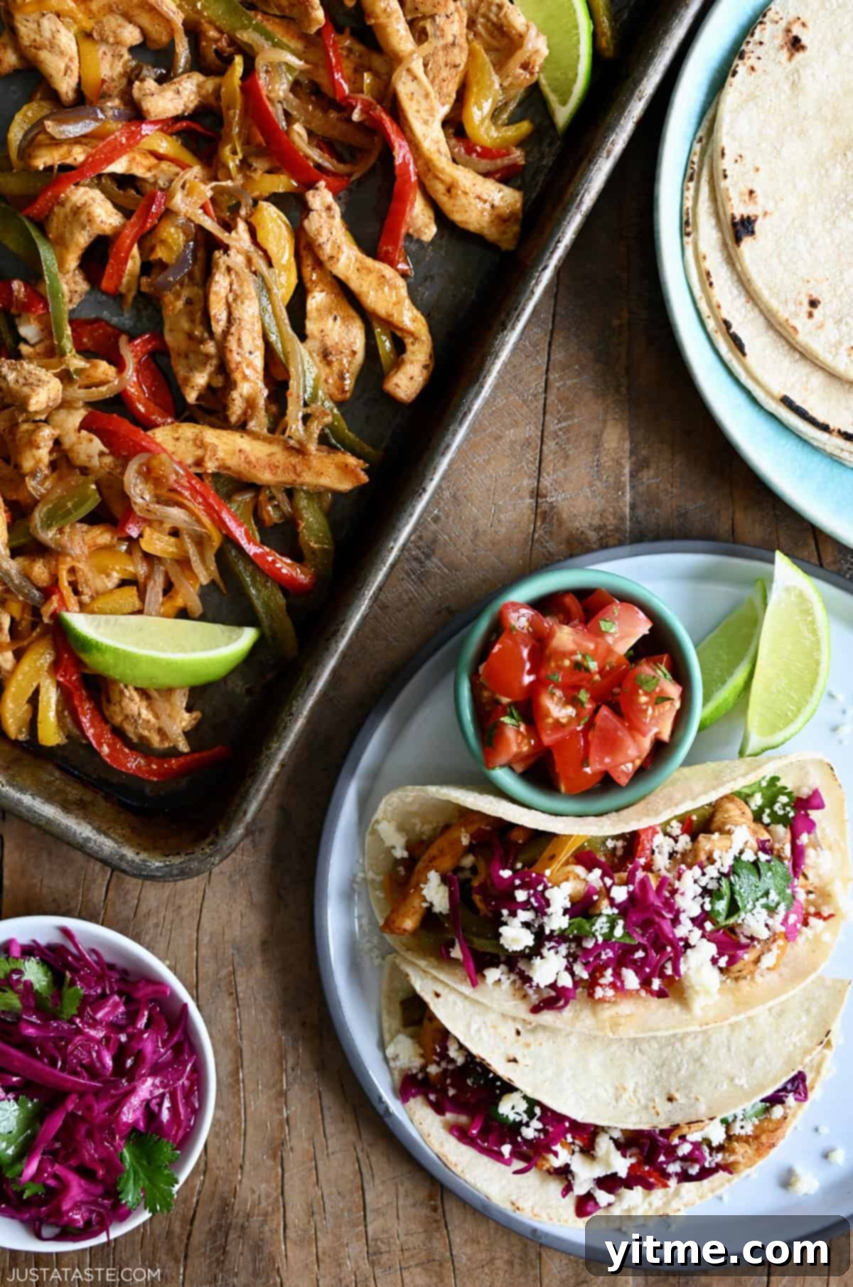 Sheet pan chicken fajitas next to a plate with tortillas and another with tacos and a small bowl containing pico de gallo.