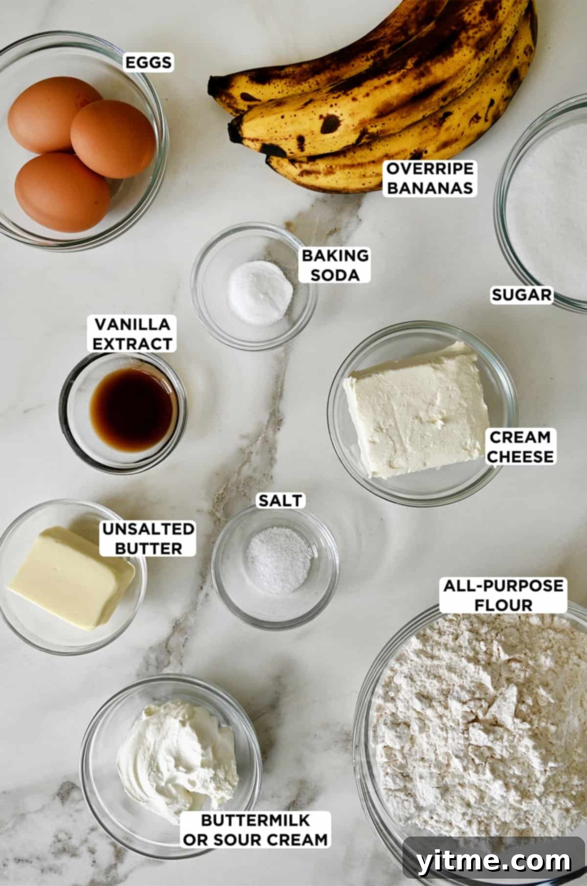 All the ingredients needed to make cream cheese-swirled banana bread, arranged in glass bowls for easy preparation.