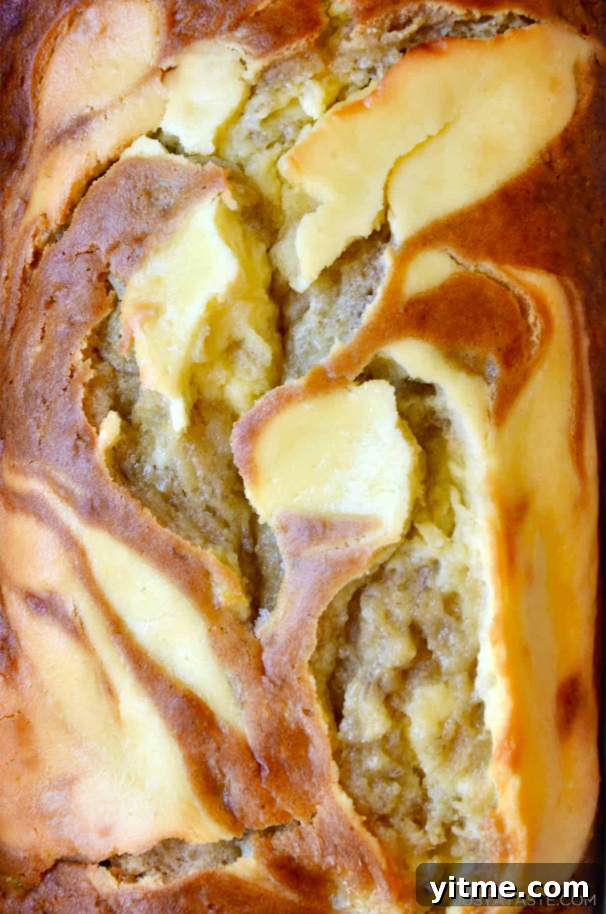 A close-up of banana bread marbled with cream cheese, showcasing its moist texture and beautiful swirl.