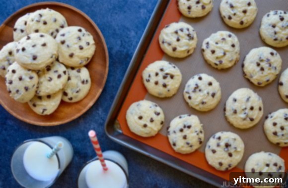 Cake mix chocolate chip cookies on a plate and baking sheet with a glass of milk