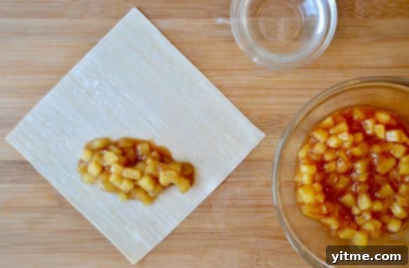 Egg Roll Wrappers and Apple Pie Filling on a Wood Cutting Board, Ready to Assemble