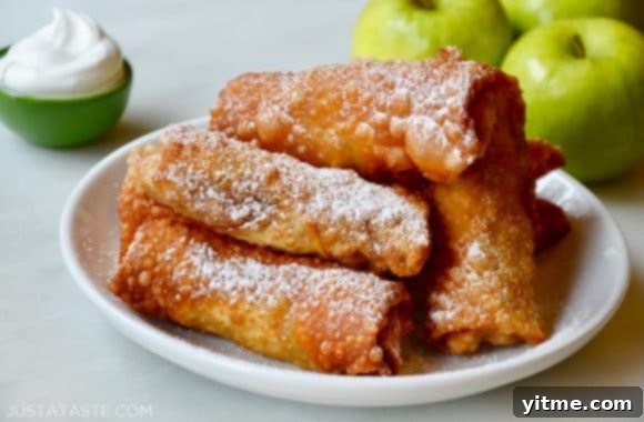 Apple Pie Egg Rolls on a White Plate Dusted with Powdered Sugar, Ready to Serve