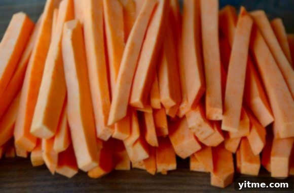 Cut, raw sweet potatoes on a wood cutting board