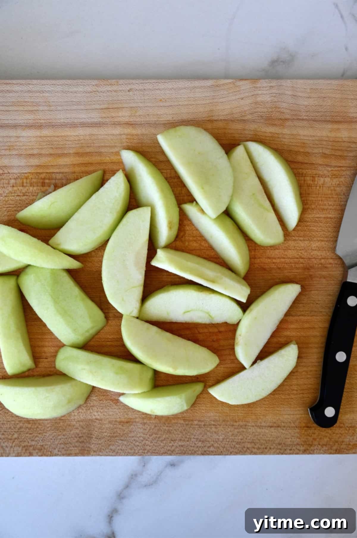 Apple Dumpling Delights: A Crescent Roll Twist 6 Granny Smith apple slices on a cutting board with a sharp knife.