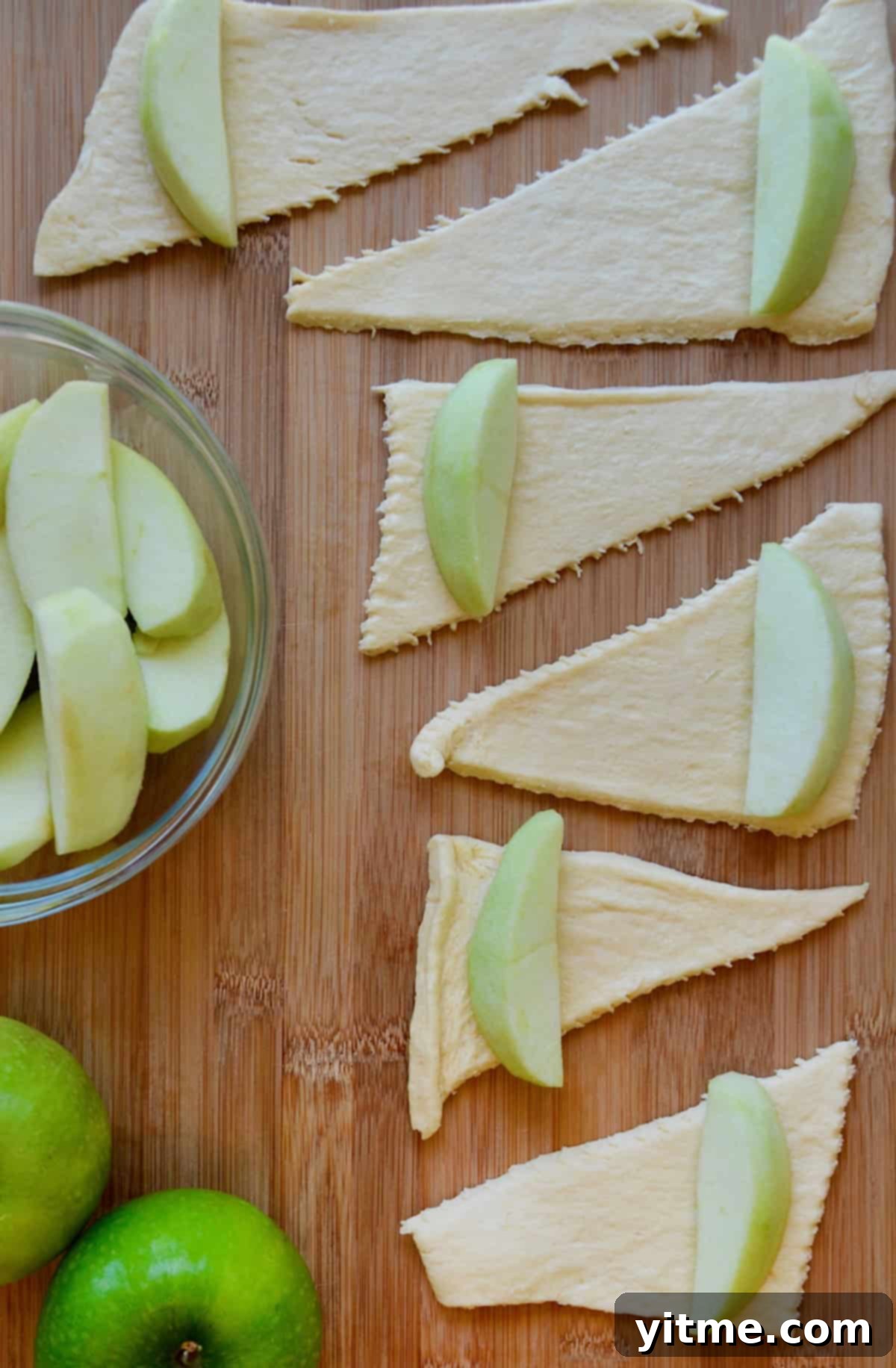 Apple Dumpling Delights: A Crescent Roll Twist 7 Close-up of wrapping an apple slice with crescent roll dough.