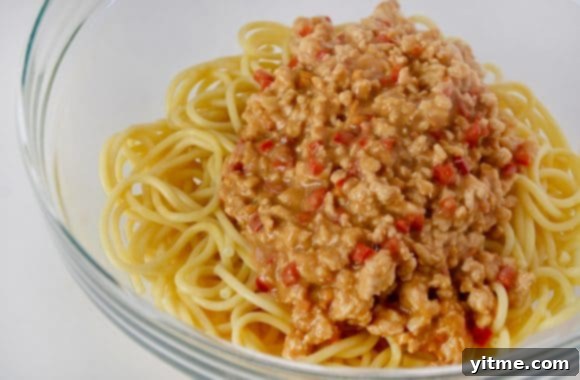 Clear bowl containing cooked pasta and turkey mixture, ready for serving