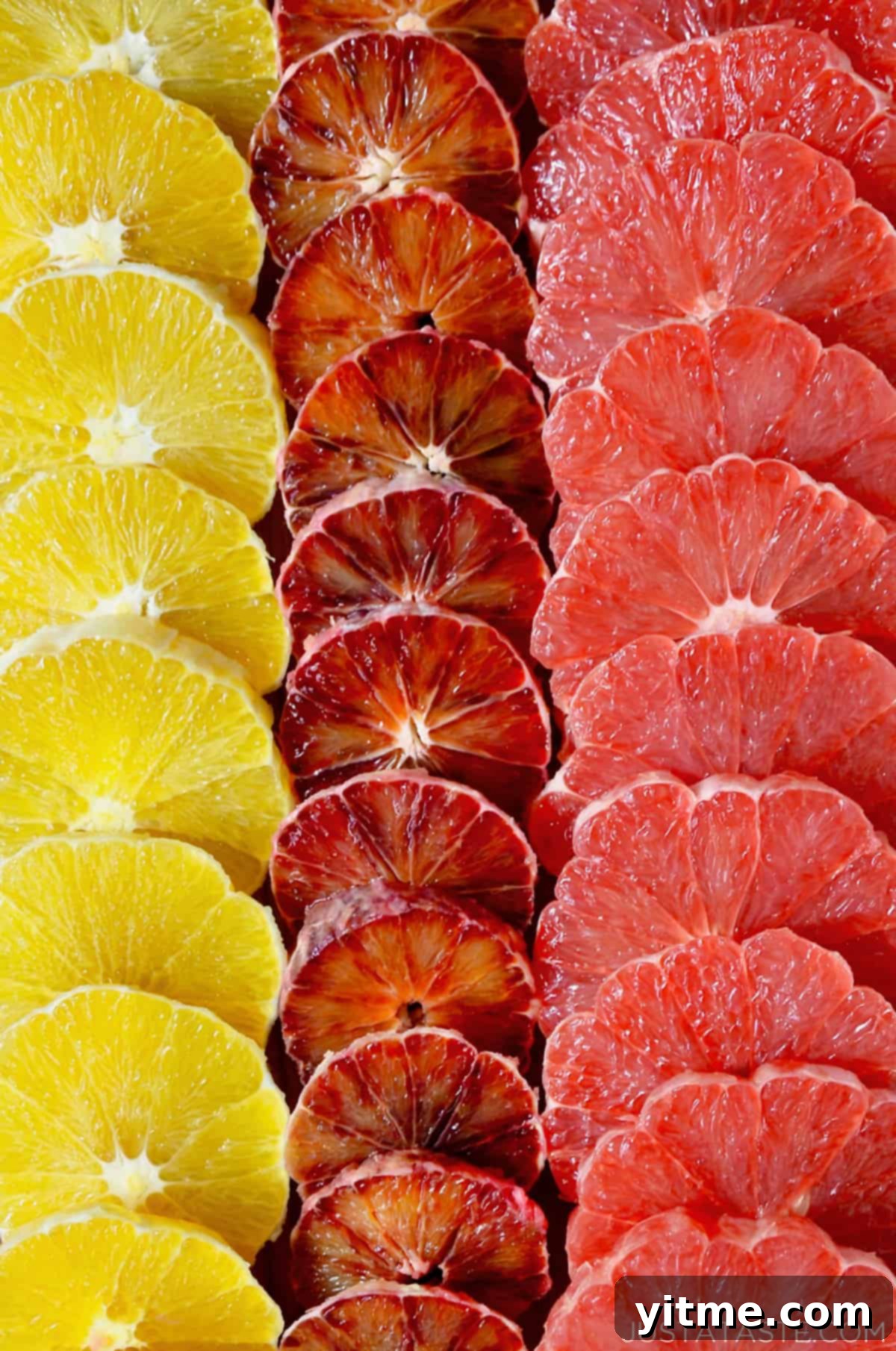 Three vertical rows of peeled, sliced oranges, blood oranges and grapefruits.