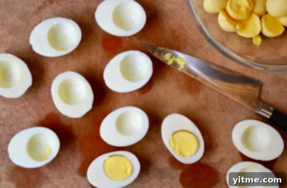 A wood cutting board with hardboiled eggs cut in half