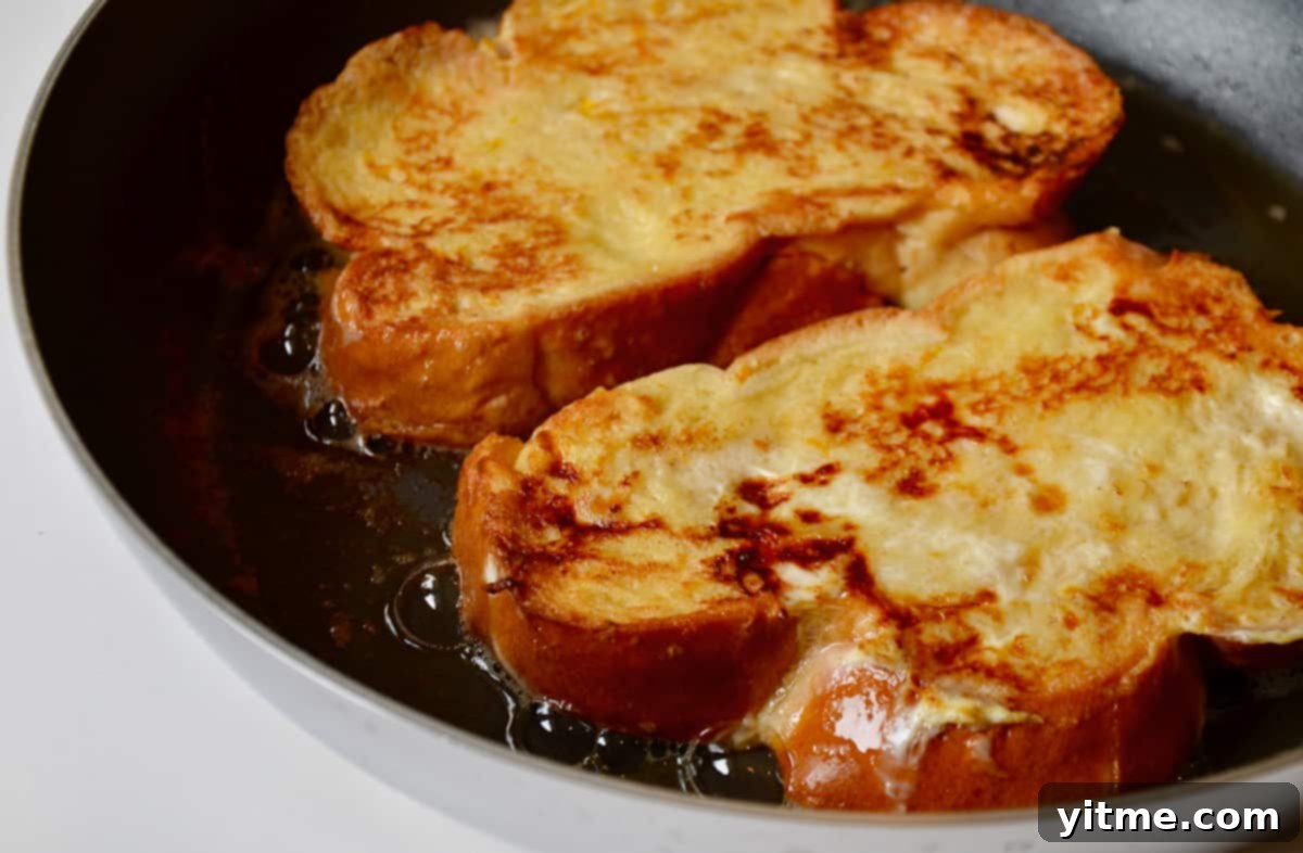 Challah french toast cooking in a saute pan