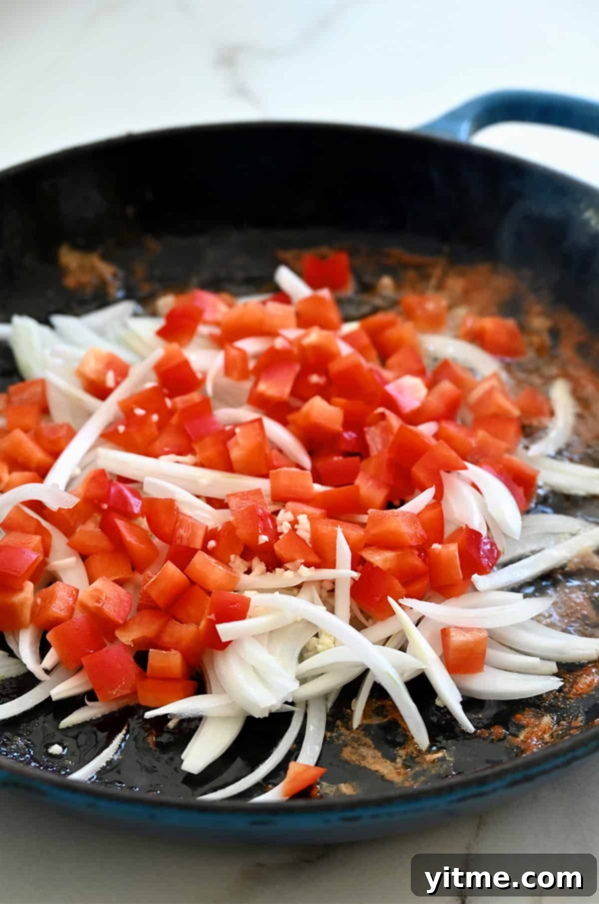 Red pepper and onion cooking in skillet.