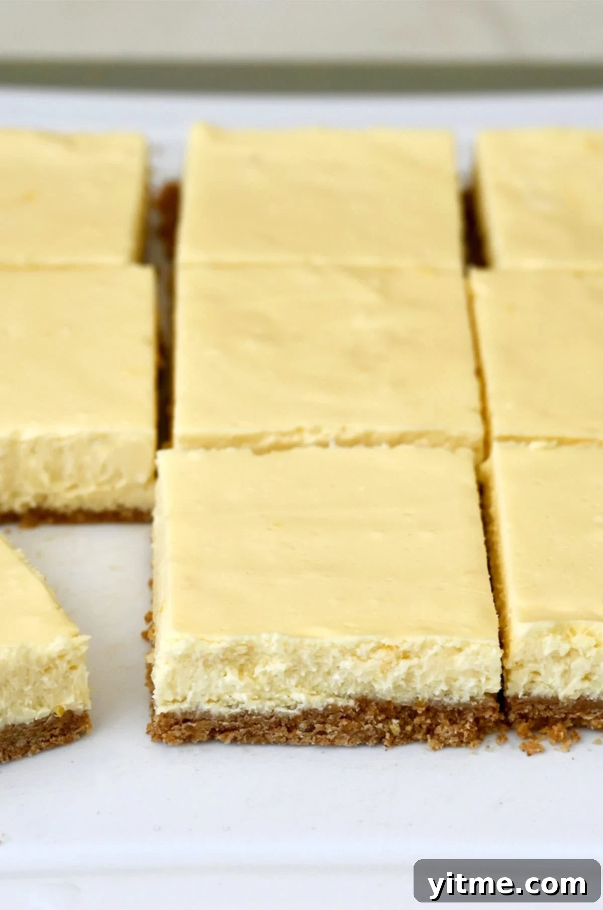 Sliced cheesecake bars with graham cracker crust.