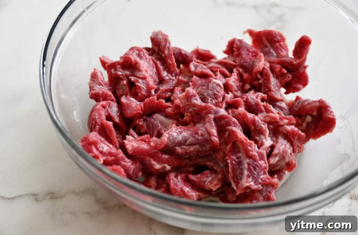 Raw beef slices in a cornstarch slurry mixture