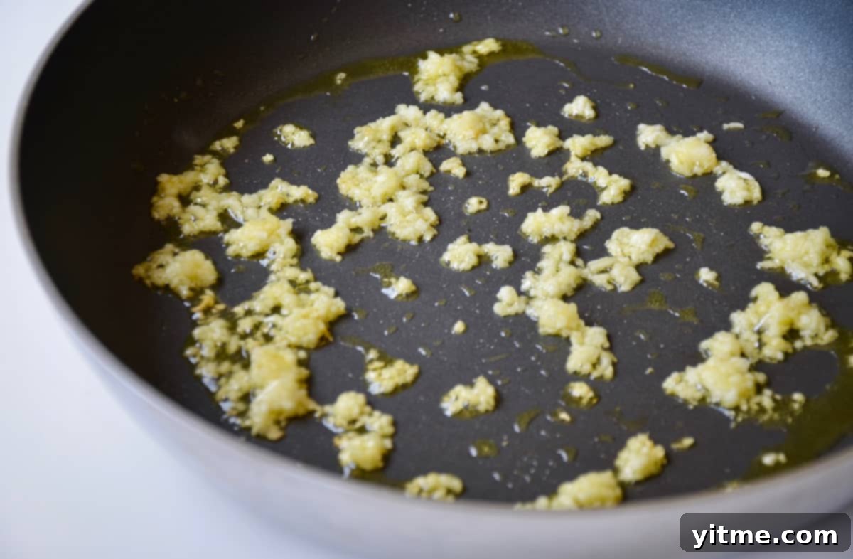 Minced garlic sautéing in a skillet