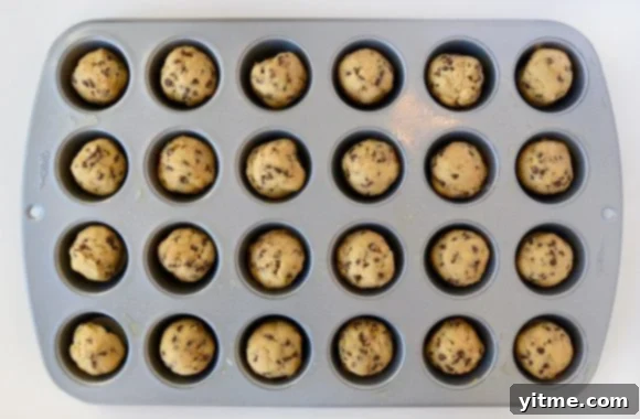 Muffin Tin Chocolate Chip Cookie Treats 5 A mini muffin tin containing balls of unbaked chocolate chip cookie dough