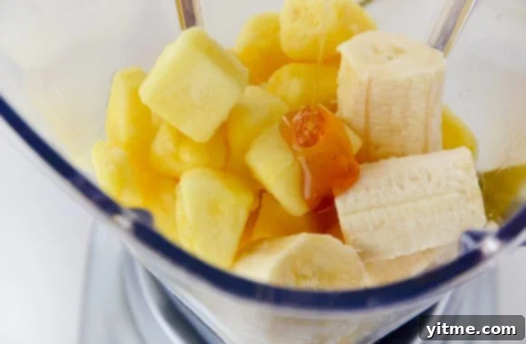 Tropical Paradise Smoothie 3 Pineapple and banana chunks with honey in blender