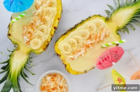 Tropical Paradise Smoothie 5 Creamy Coconut Pineapple Smoothies in hollowed out pineapples topped with sliced bananas and coconut