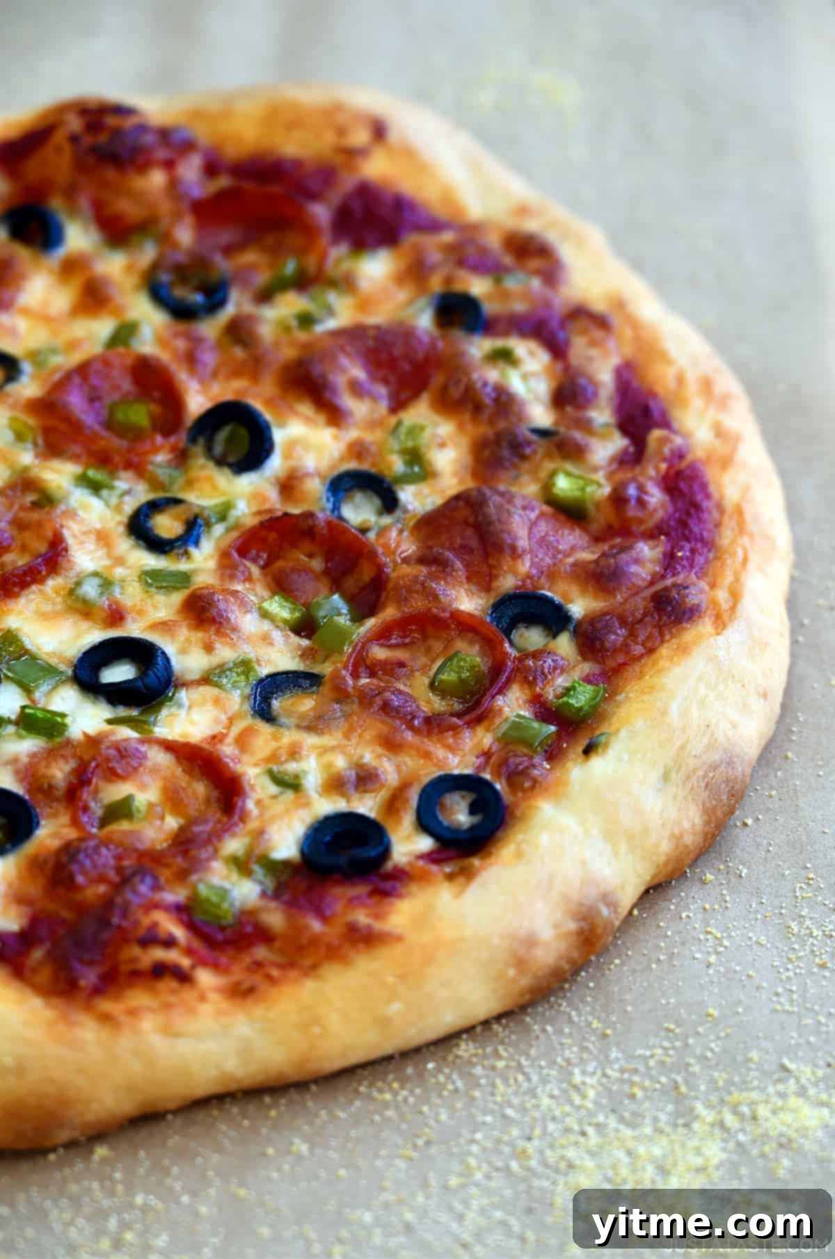 A deliciously soft pizza crust, generously topped with vibrant marinara sauce, savory black olives, classic pepperoni, crisp green peppers, and gooey mozzarella cheese, baked to golden perfection.