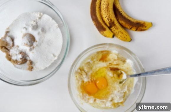 Ingredients for Sour Cream Chocolate Chunk Banana Bread: Overripe bananas, wet and dry ingredients in bowls