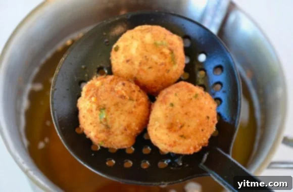 Golden Fried Leftover Mashed Potato Balls being scooped from hot oil