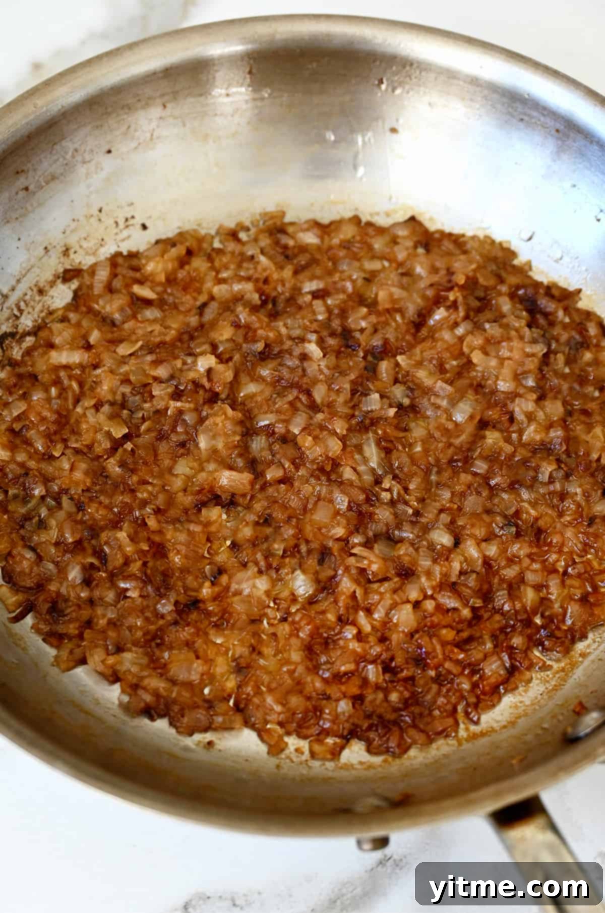 Elevated Homemade French Onion Dip 4 Caramelized onions cooking in a skillet.