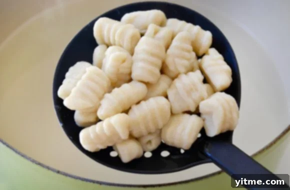 Repurposed Mashed Potato Gnocchi 5 Mashed potato gnocchi in slotted spoon over large pot