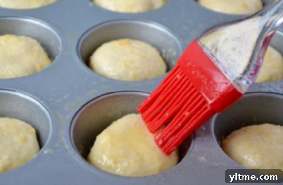 Brushing the tops of unbaked pizza pockets with a flavorful garlic butter mixture