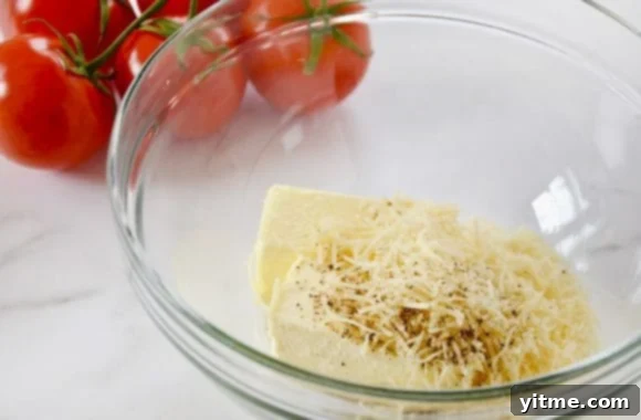 Fresh Caprese Garlic Bread 4 A glass bowl containing butter, shredded Parmesan cheese, minced garlic and pepper with vine-ripe tomatoes in background