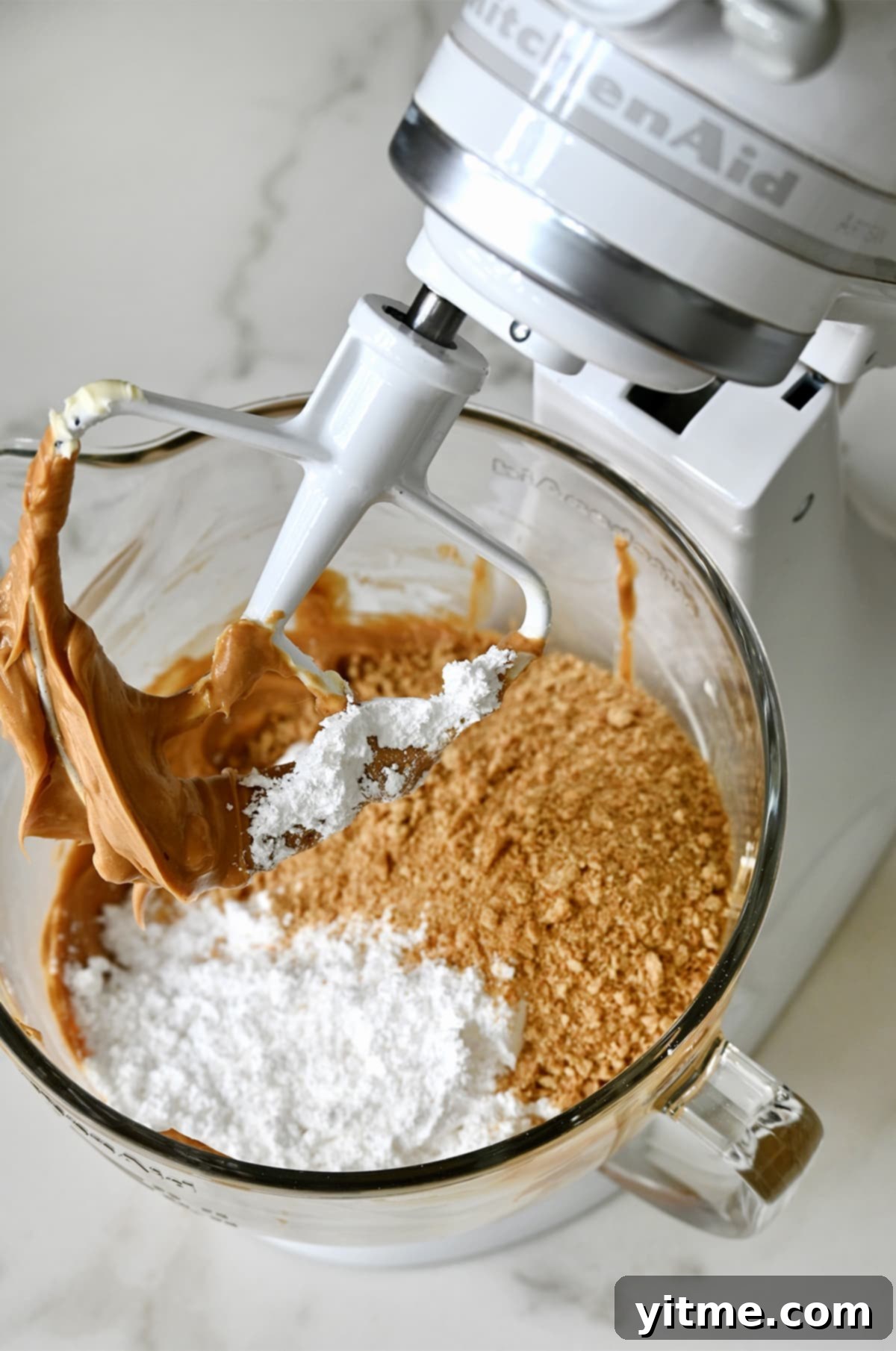Creamy peanut butter, graham cracker crumbs, and powdered sugar in a mixing bowl.