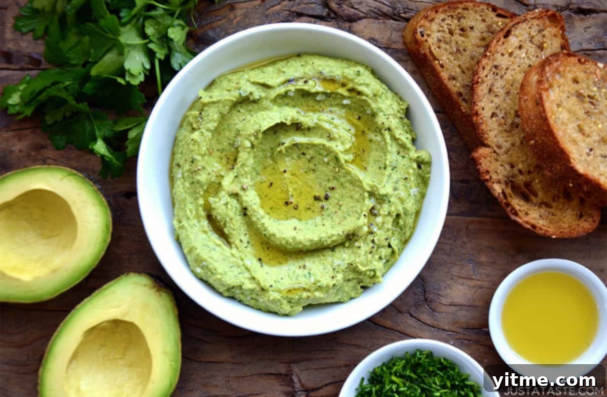 Avocado hummus in a bowl topped with olive oil, salt, and pepper