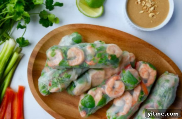 Thai Spring Rolls on a wood serving plate with peanut sauce