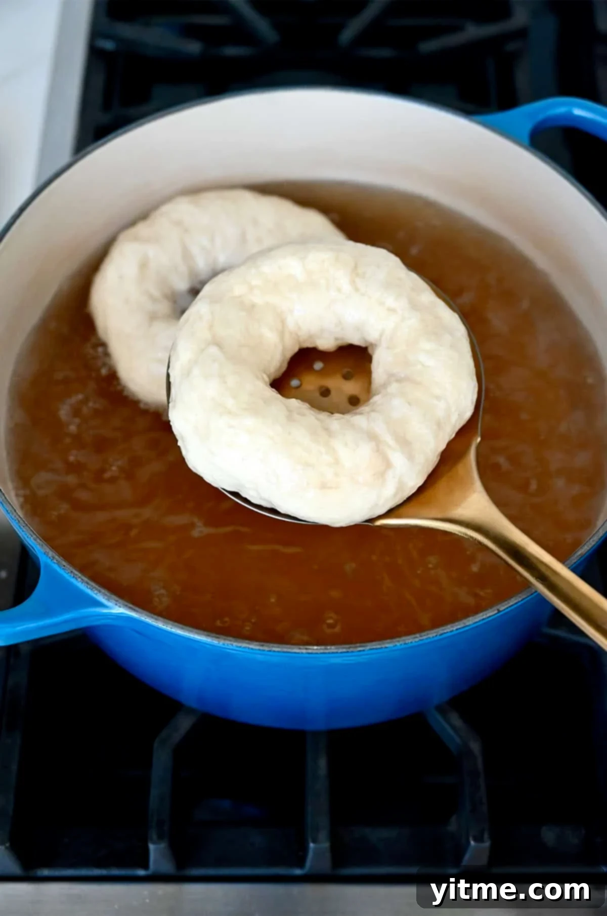Boiling bagel dough in a water and honey bath.