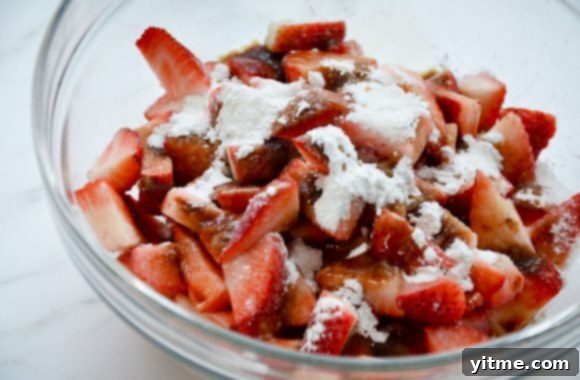 Glass bowl containing fresh strawberries and sugar