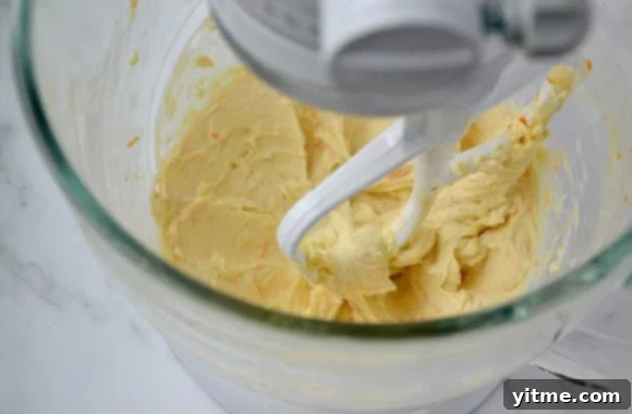 Cream cheese mixture with orange zest in a mixing bowl