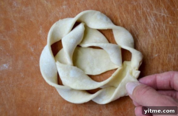 Close-up of puff pastry being twisted into a danish