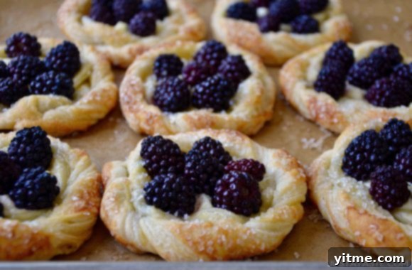 Rows of blackberry cream cheese pastries on a baking sheet, ready to be enjoyed