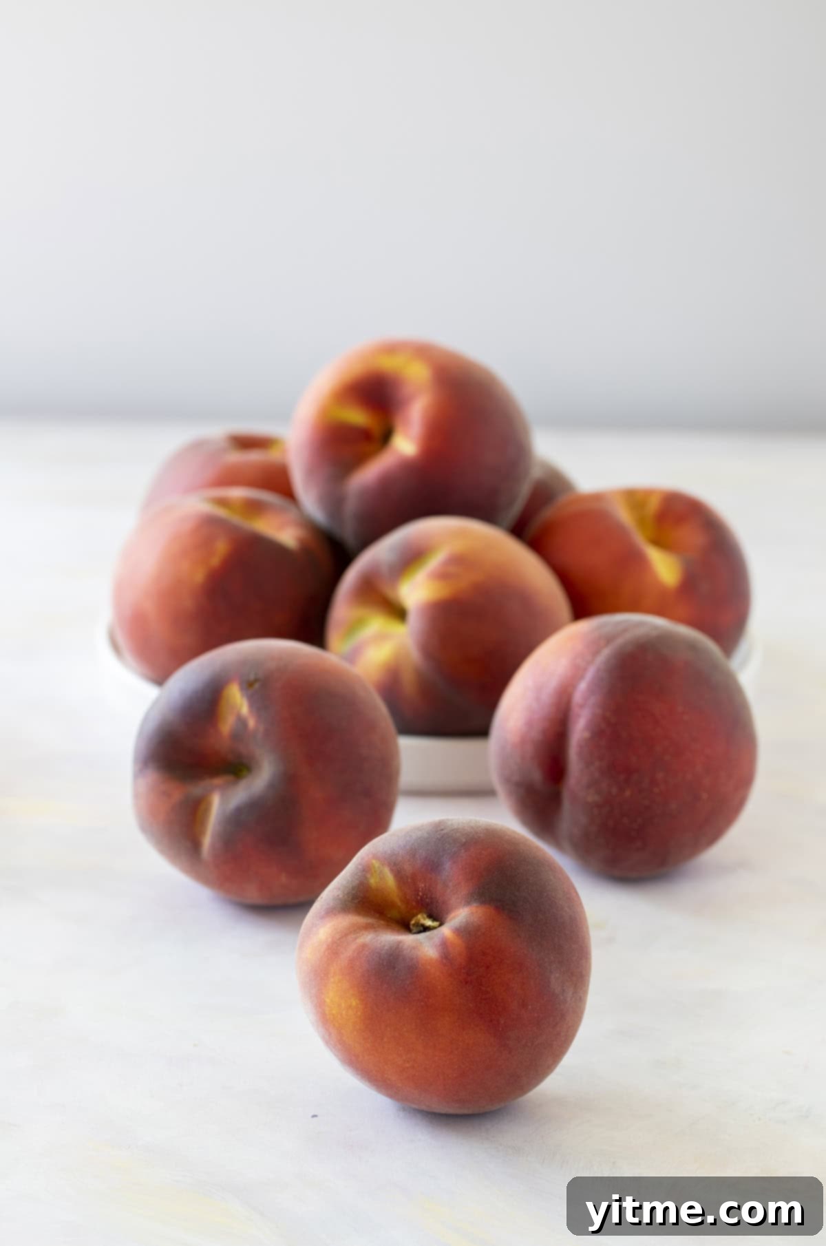 Fresh, ripe peaches on a marble countertop.