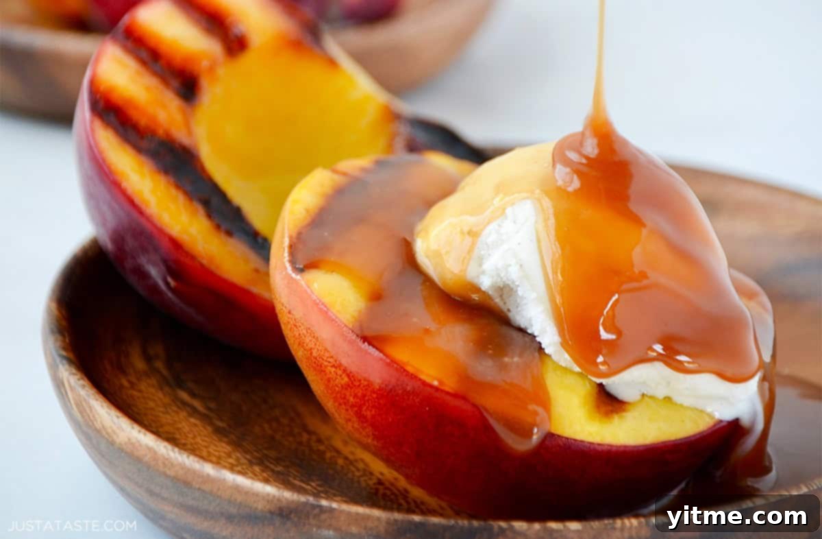 Grilled peaches with vanilla ice cream and bourbon caramel sauce, showcasing char marks.