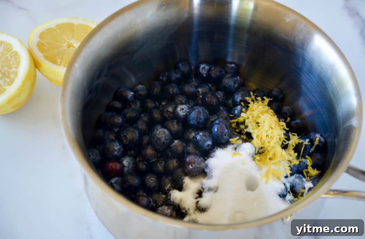 Blueberries, sugar, and lemon zest simmering in a saucepan